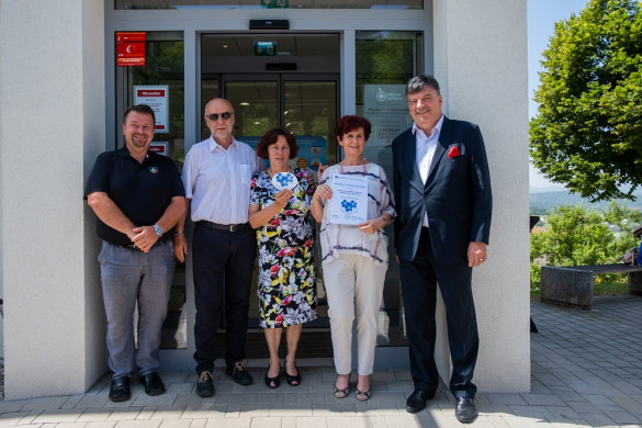 Skupinska fotografija direktorja Lekarne Ljubljana, predsednice Združenja Spominčica, vodje lekarne, župana in direktorja občinske uprave pred Lekarno pri ZD Grosuplje ob otvoritvi DPT